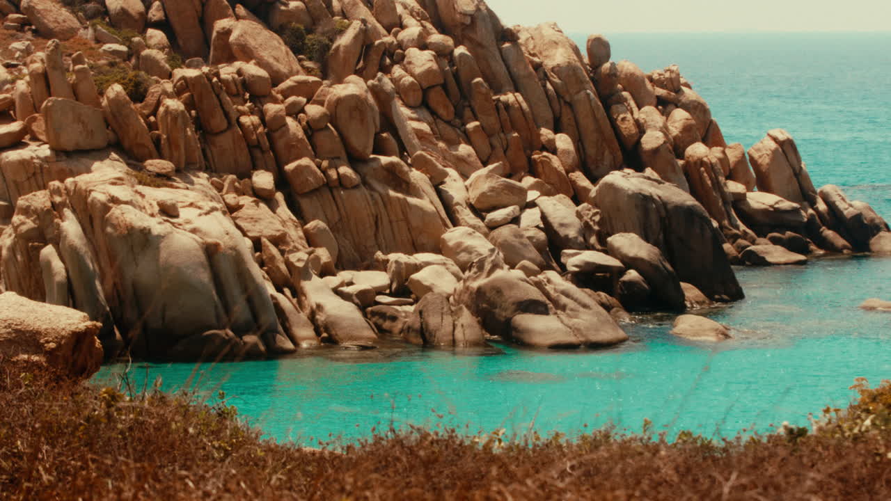 해안가 바위와 르키즈색 물