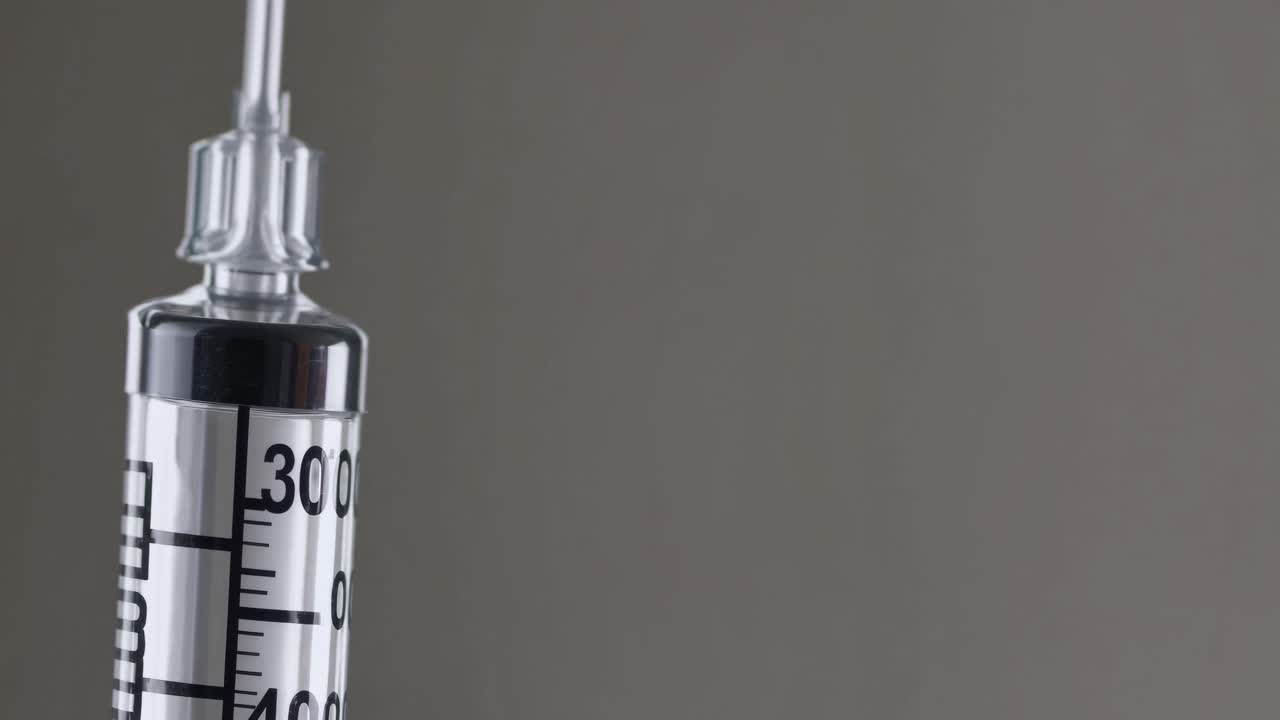 Primo piano di siringa medica che espelle liquido