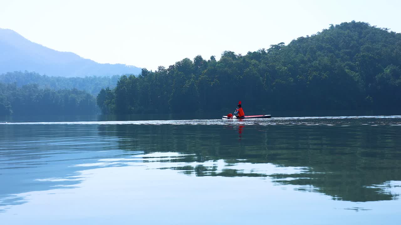Kayaker paddling peacefully on a serene lake