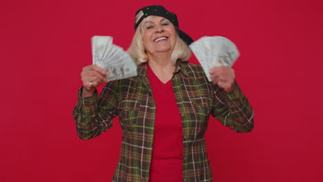 rico satisfecho jefe mujer sénior agitando dinero dólares billetes en efectivo como un fan éxito carrera de negocios