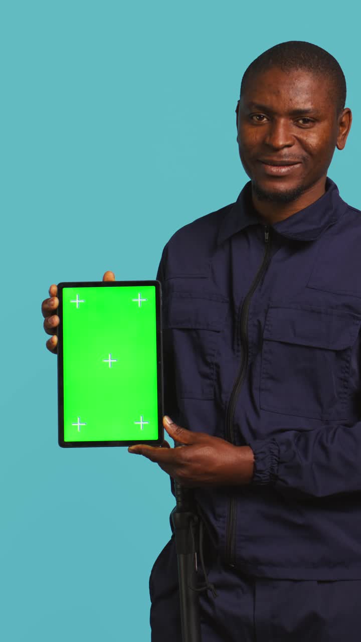 Uomo afroamericano che tiene in mano un tablet con schermo verde per pubblicità