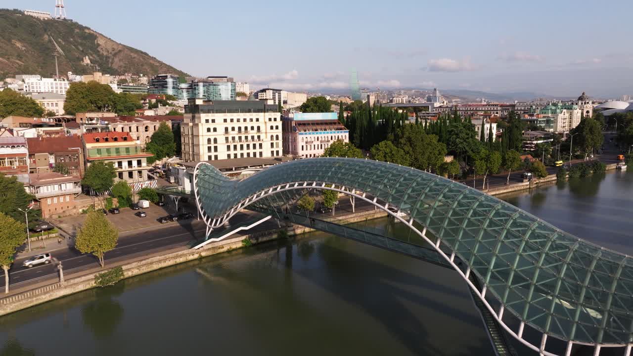Aerial Establishing View Above Kura River, Bridge of Peace in Downtown Tbilisi