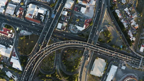 Vista-Aérea-De-Una-Intersección-De-Carreteras-Con-Tráfico-En-Una-Puesta-De-Sol