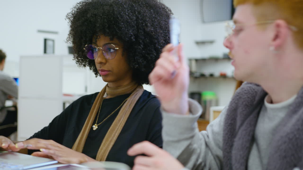 Young Black Businesswoman Having Talk with Coworker in the Office