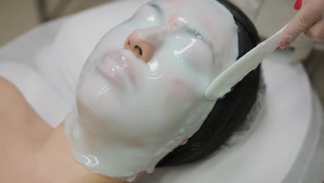 un tratamiento facial calmante con una capa gruesa de máscara de alginato que se aplica para el rejuvenecimiento e hidratación de la piel