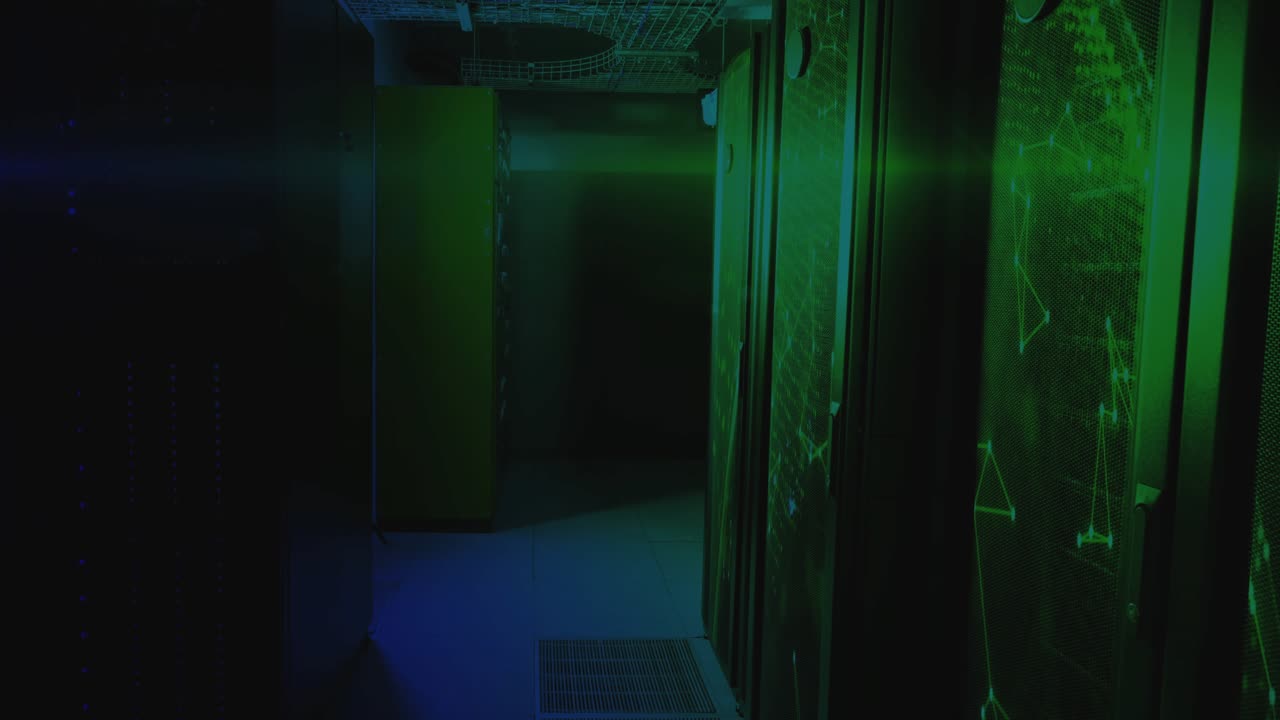 Camera panning into dimly lit server racks while network scan data scrolling for status monitoring