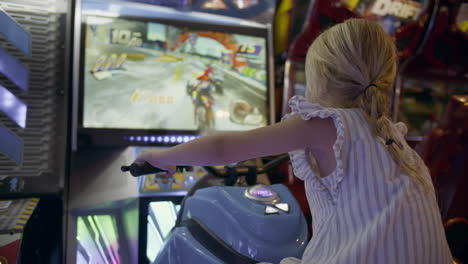 niña jugando a un juego de arcade de carreras de motos de nieve.