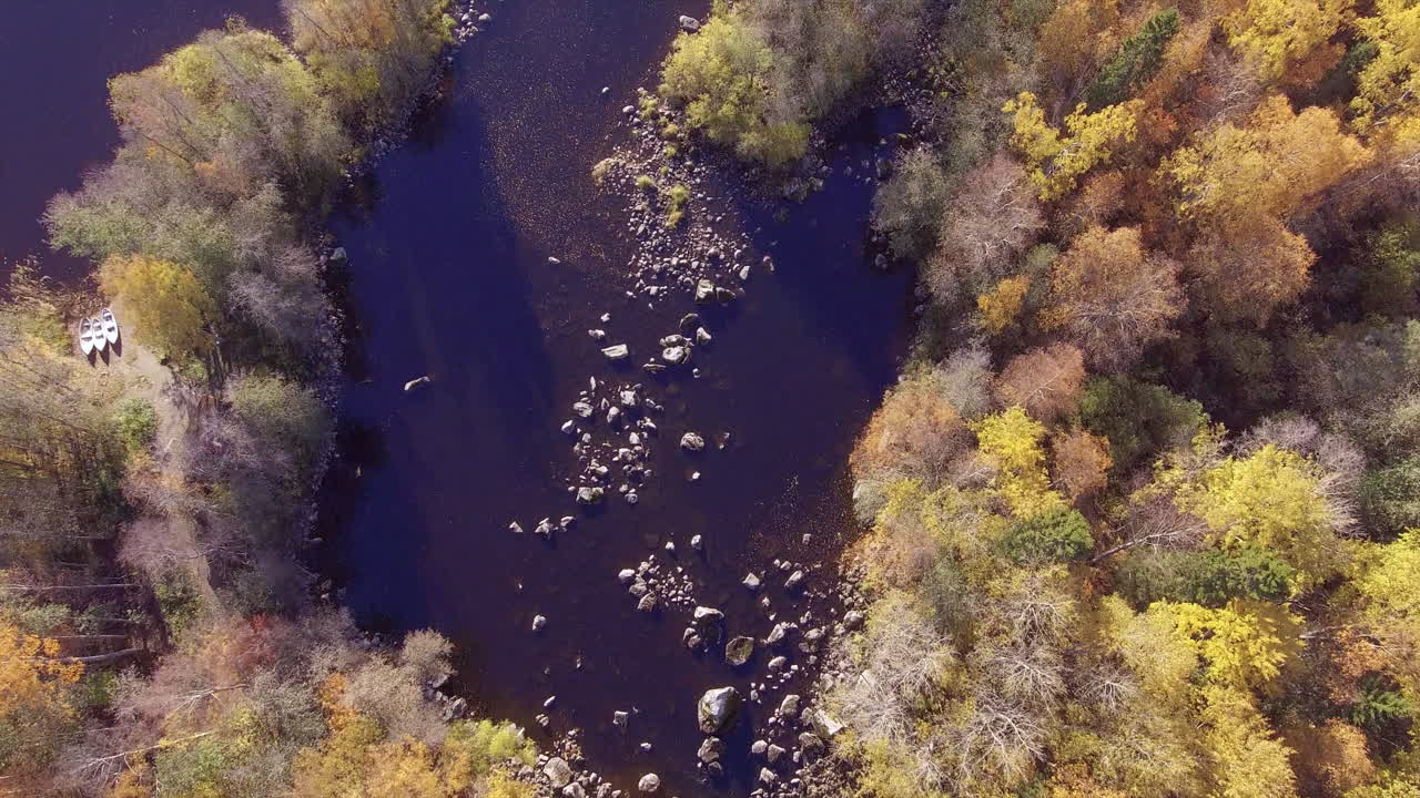 hermoso video de sobrevuelo de drones de un río en el desierto con tres botes en tierra esperando para ir a pescar