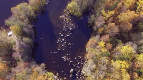 beautiful drone overflight video of a river in the wilderness with three boat on land waiting to go for fishing
