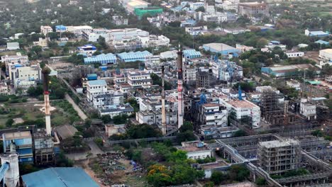 an aerial perspective of a complex industrial site. the dense network of pipes and structures, with smokestacks dominating the skyline, represents heavy industry and its environmental footprint