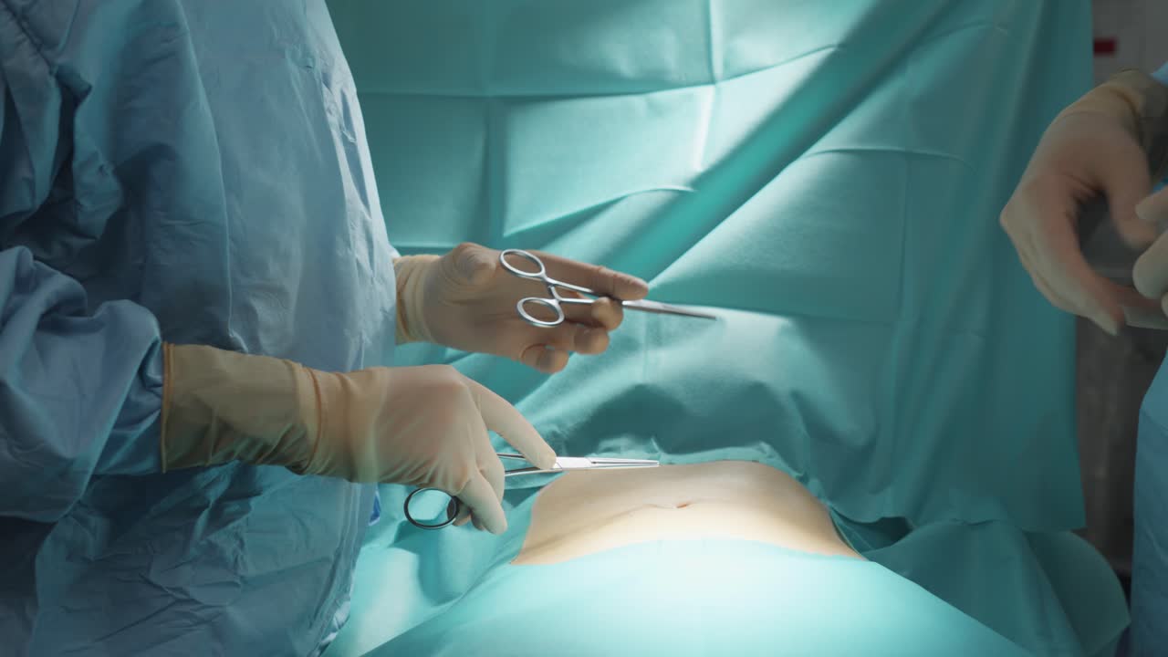 primer plano de un campo quirúrgico en un hospital, con un cirujano completamente equipado a la izquierda recibiendo tijeras de otro cirujano a la derecha, listo para operar al paciente