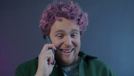 man talking on phone with pink hair