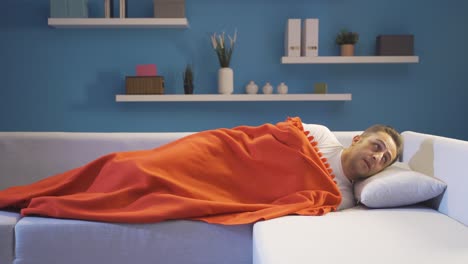 hombre en la cama mirando a su alrededor con miedo y ansiedad.