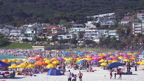 establishing shot of a beautiful busy holiday beach scene at camps bay cape town south africa