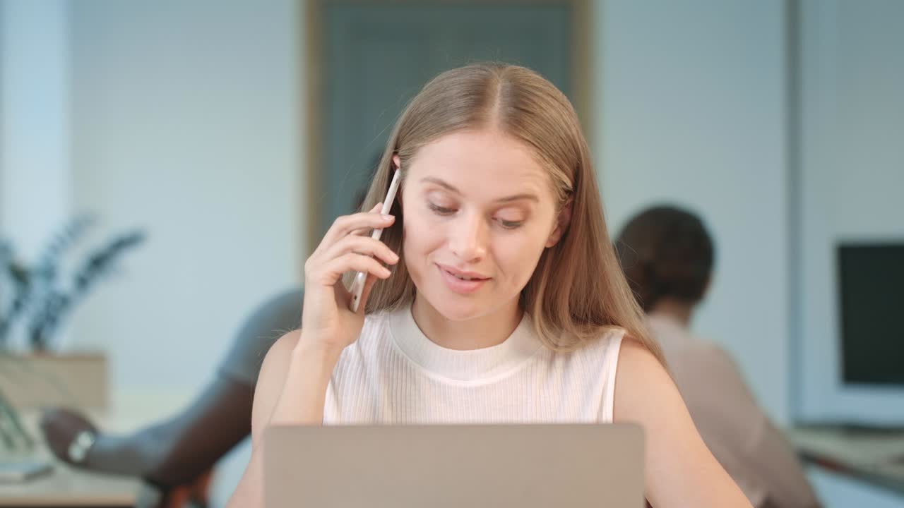 Young woman working at laptop in business office. Portrait of concentrated woman