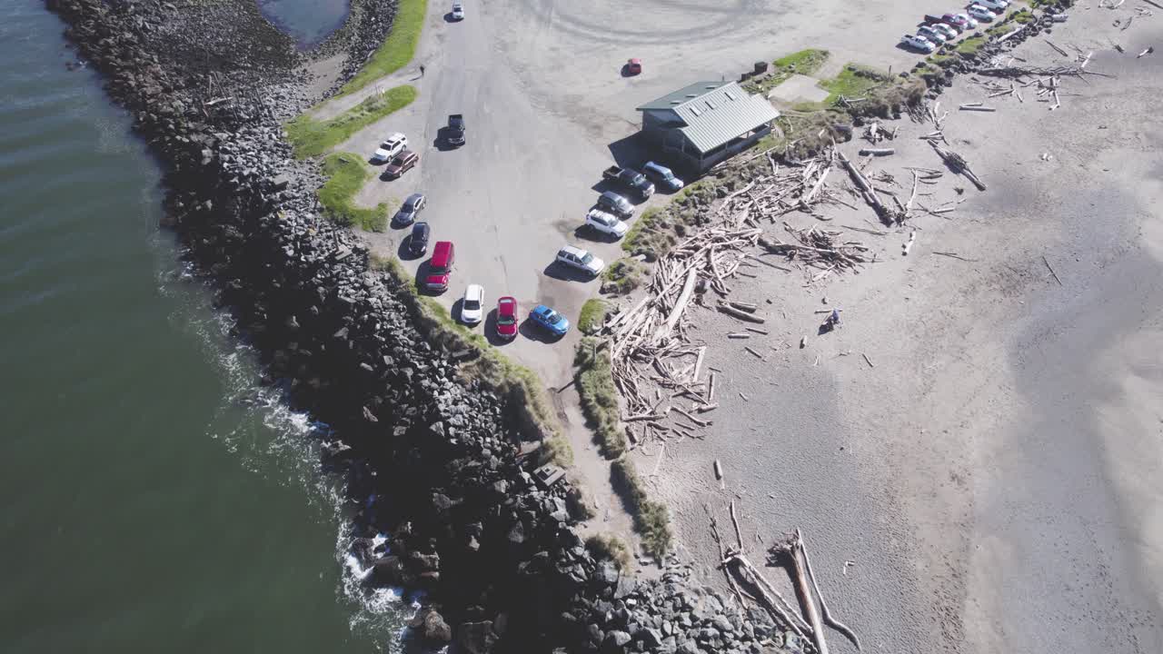 rompeolas por costa y playa llena de grandes trozos de madera en bandon oregon