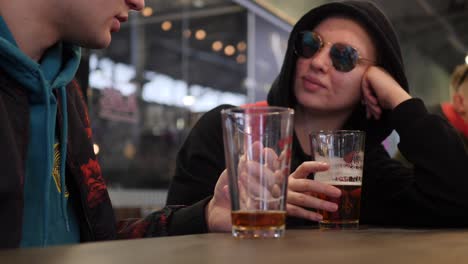 Slow-motion-shot-of-old-friends-sitting-in-the-bar,-talking-and-drinking-bear