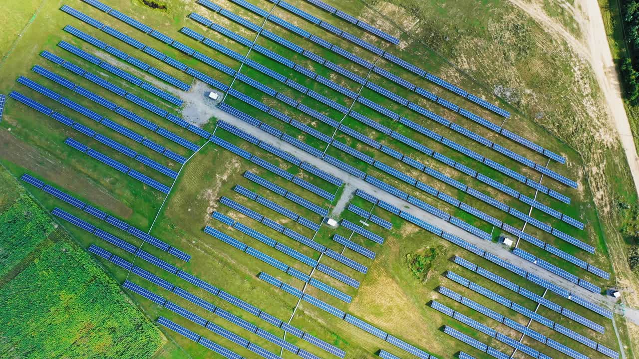 Solar energy panels on the field. Top aerial view on the solar power farm. Renewable green alternative energy concept. Motion camera around.