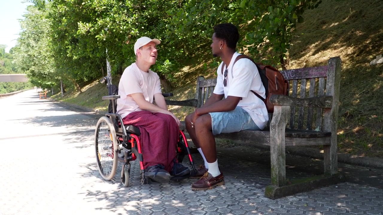 Due ragazzi che conversano amichevolmente su una panchina del parco