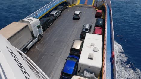 view of parked cars, lorry and camper vans on deck of ferryboat crossing the sea