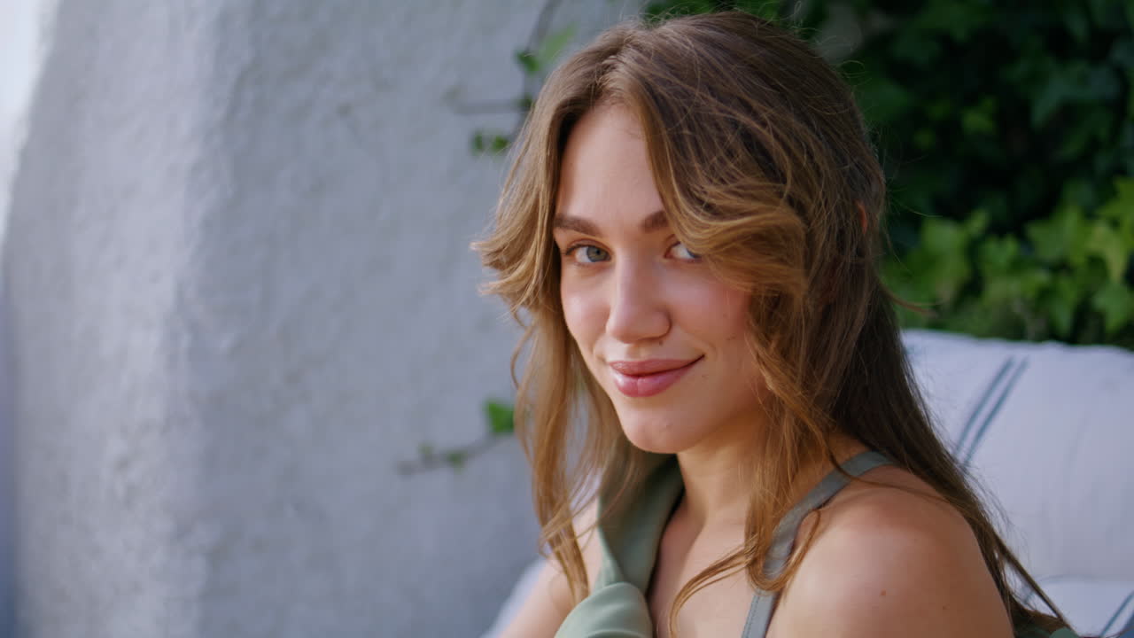 Gorgeous woman smiling camera sitting at serene outdoors setting closeup