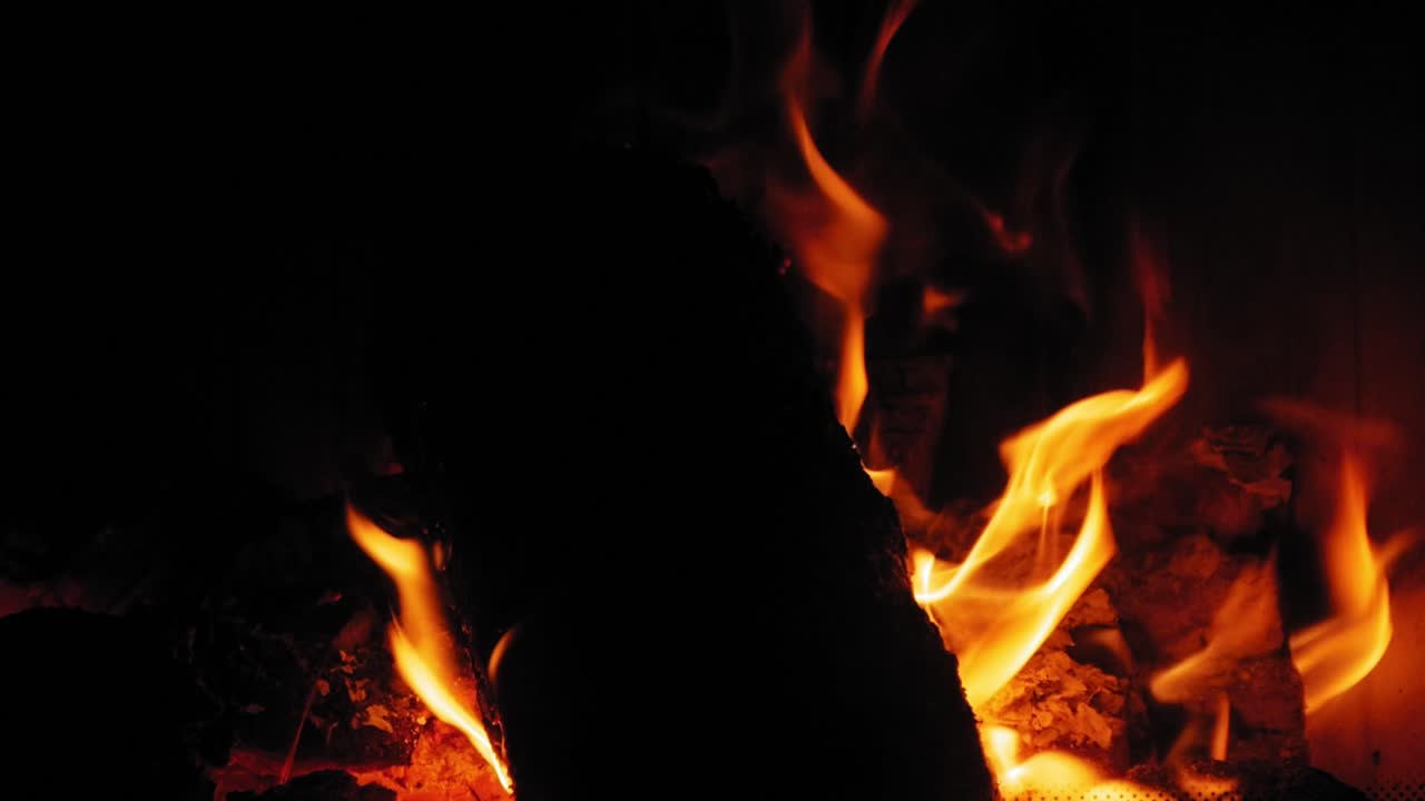 Fiamma ardente nel camino su ciocchi di legno