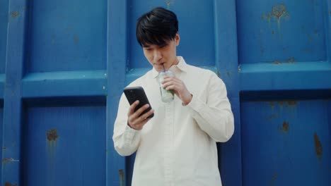 젊은이 가 전화 를 사용 하고 술 을 마시는 것