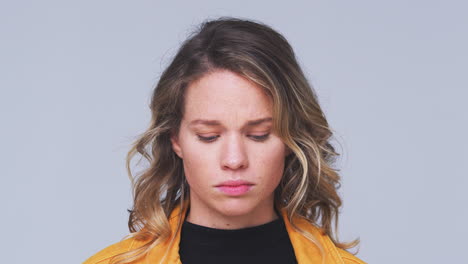 head and shoulders studio shot of woman looking at camera with serious expression in slow motion