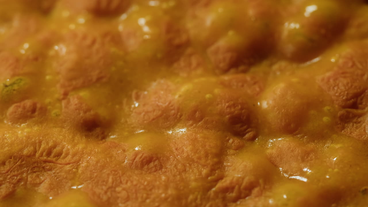 Yellow boiling sauce on pan close-up. Asian cuisine concept. Curry is a dish with a sauce seasoned with spices. Curries may contain fish, meat, poultry, or shellfish, either alone or in combination with vegetables. Others are vegetarian.