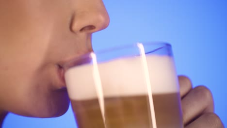 Close-up-mouth-and-lips,-woman-enjoys-fresh-brewed-coffee,-isolated-blue-back