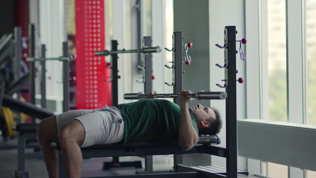 hombre realizando ejercicio de press de banca en el gimnasio