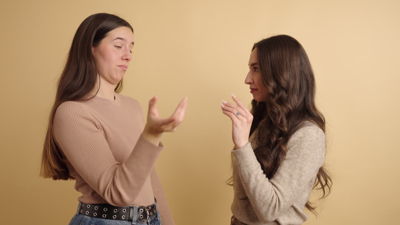 Young women showing blah blah gestures with raised hands