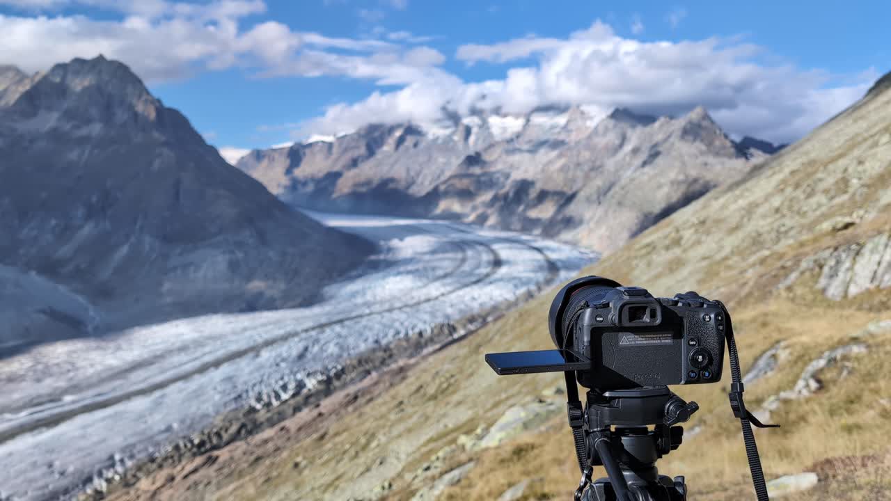 Professional camera filming glacier in Swiss mountains on a windy day, Aletsch glacier