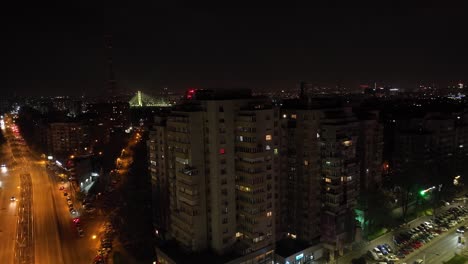 high-rise buildings and traffic driving in the streets at night in bucharest, romania