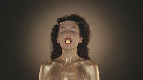 woman with gold body art and jewelry