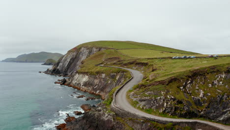 Aerial-footage-of-sea-washing-rocky-coast.-Road-and-car-park-near-nature-landmark-popular-with-tourist.-Sheep-grazing-in-the-pastures.-Ireland