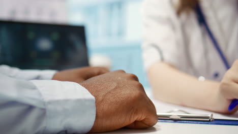 specialist comforting patient in cabinet by holding his hand and supporting