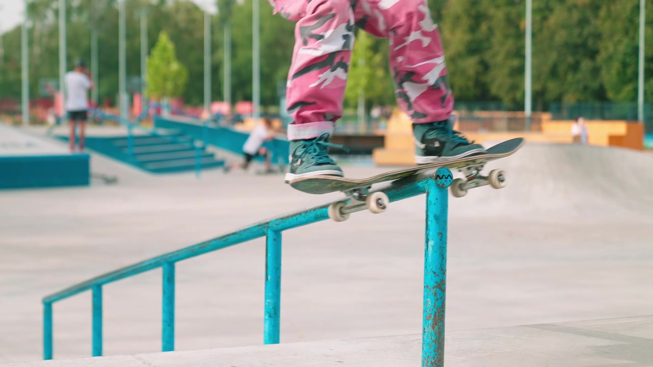 Skateboarder Performing a Grind Trick on a Rail in a Skatepark