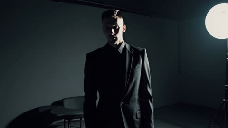 dramatic portrait of a man in a suit under spotlight