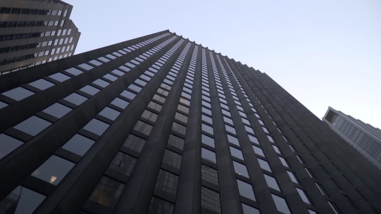 Up view of black building in New York City Manhattan suring sunny day in slow motion.