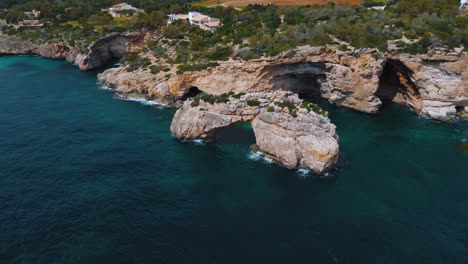 Natural-arch-Es-Pontas,-remote-bay,-clear-blue-turquoise-sea-water-with-white-sand-beach