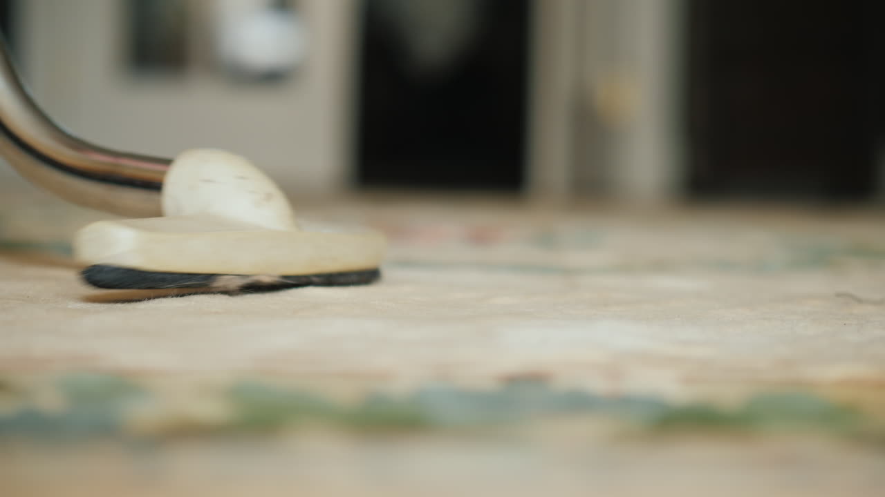 필드의 깊이가 얕은 집 비디오에서 카펫을 진공 청소기로 청소하는 여자