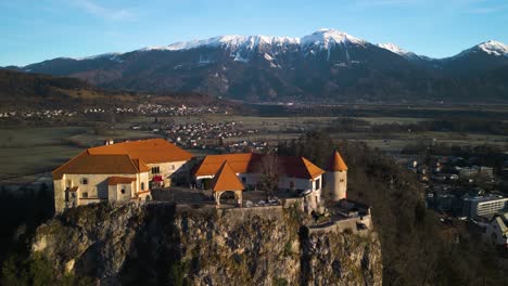el dron vuela sobre el castillo de bled con los hermosos alpes julianos en el fondo.