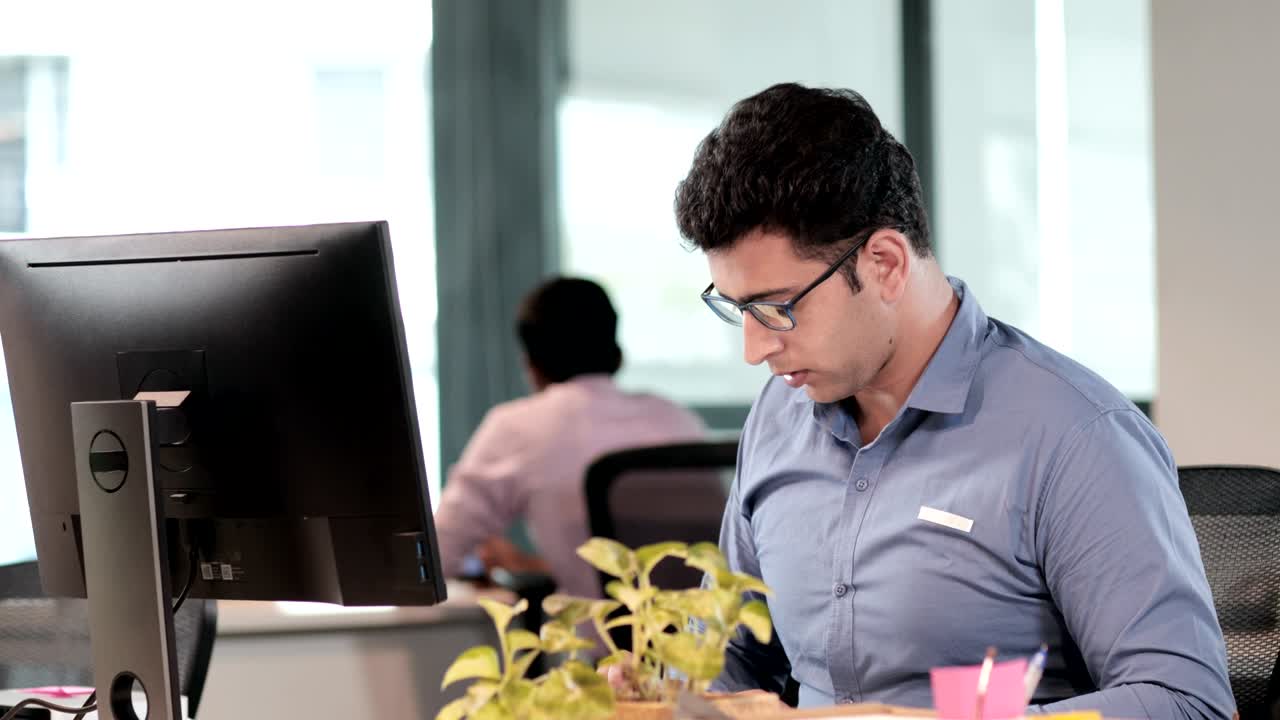 un joven empleado de oficina o empleado que trabaja en una computadora en una oficina moderna.