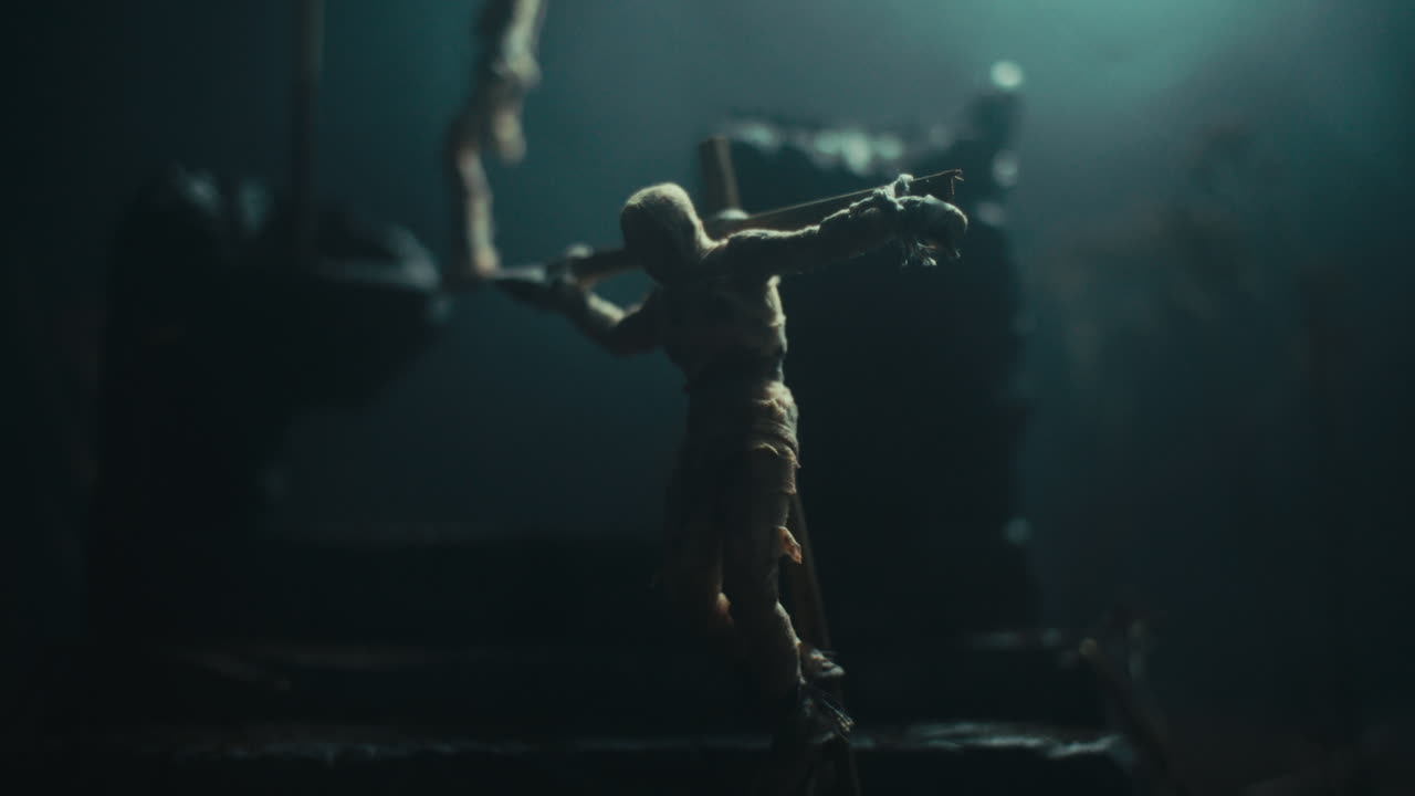 A miniature scene of the mummified dolls hanging on the gallows at night