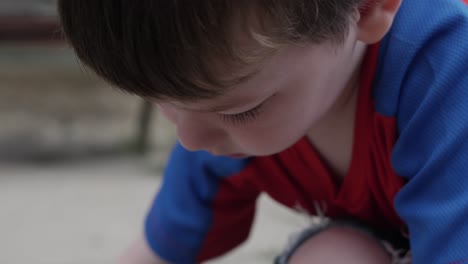 A-Young-Happy-Boy-Draws-and-Colors-With-Chalk-On-Sidewalk-Outside