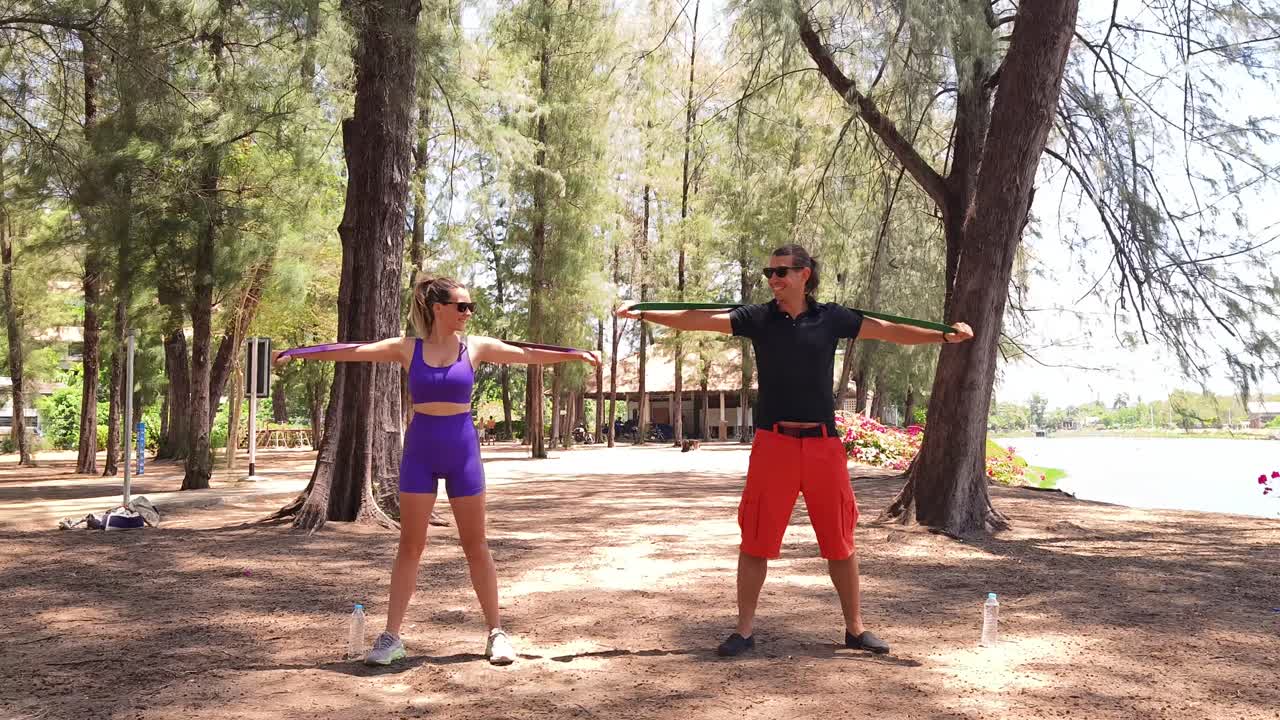 Couple working out with resistance bands in a park