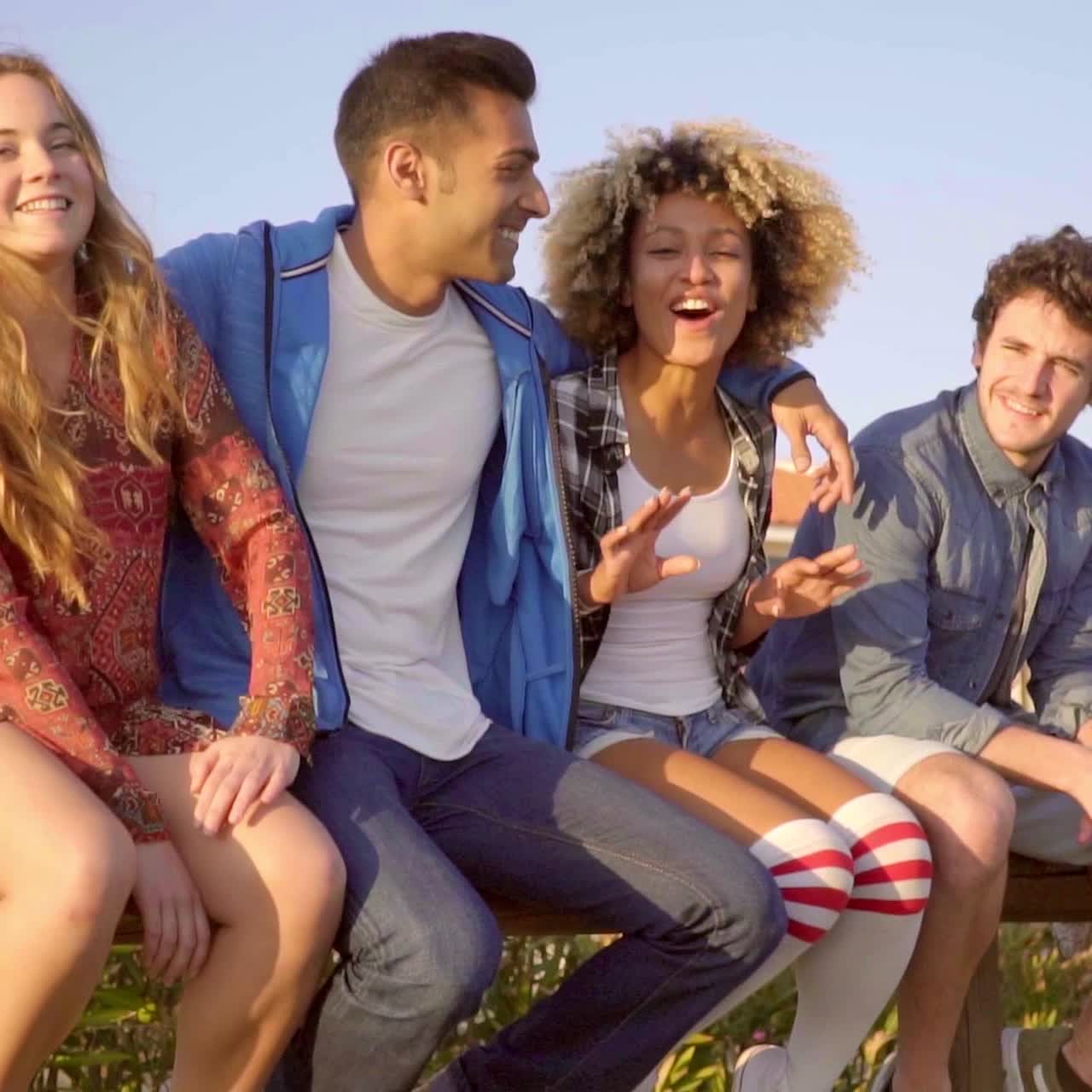 jóvenes sentados en una valla de madera