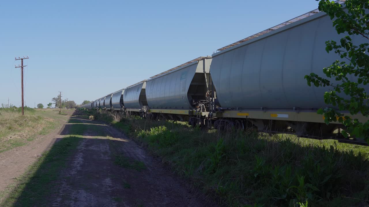 View of a freight train driving away in a rural area.