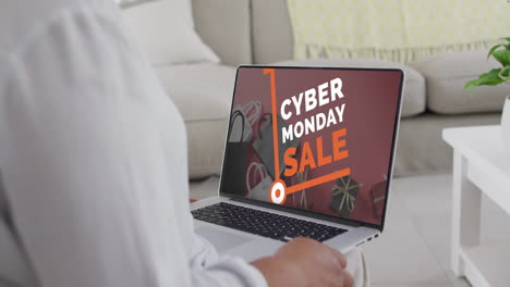 una mujer biracial usando una computadora portátil en casa comprando en línea en el día de venta del lunes cibernético, en cámara lenta